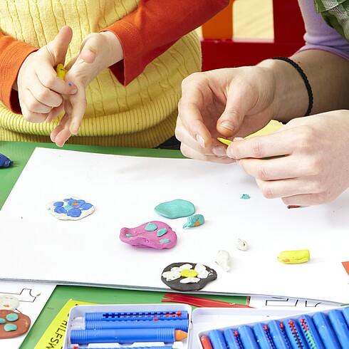 Zeichnung mit Kinderhänden sichtbar